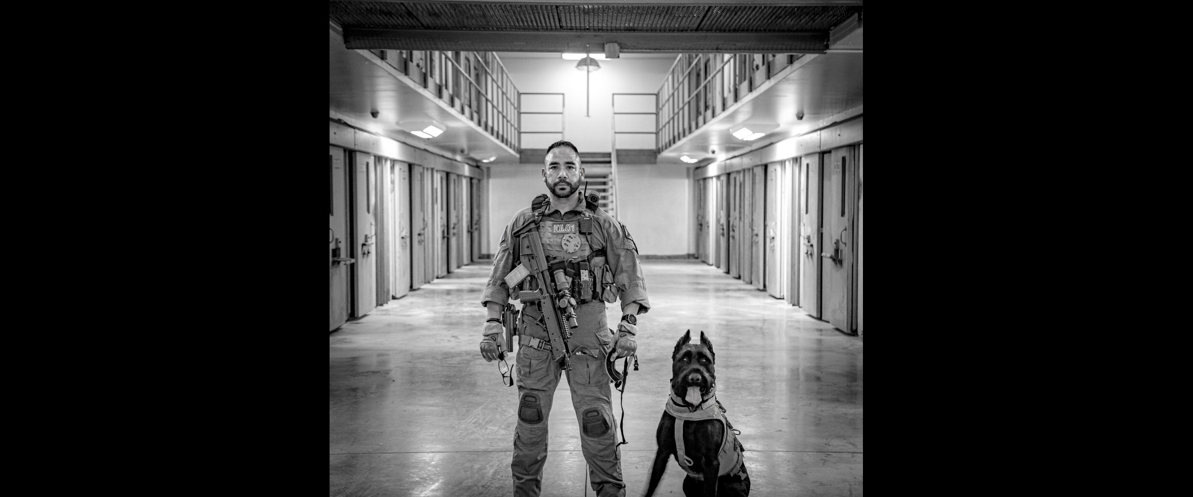 Cinematic prison-corridor scene &mdash; the operational environment behind K1K9 doctrine.